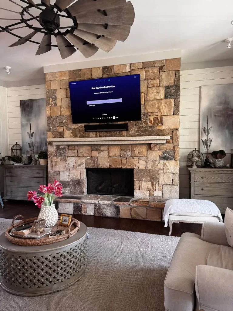 TV mounted above white stone fireplace – installation in progress in Chastain Park