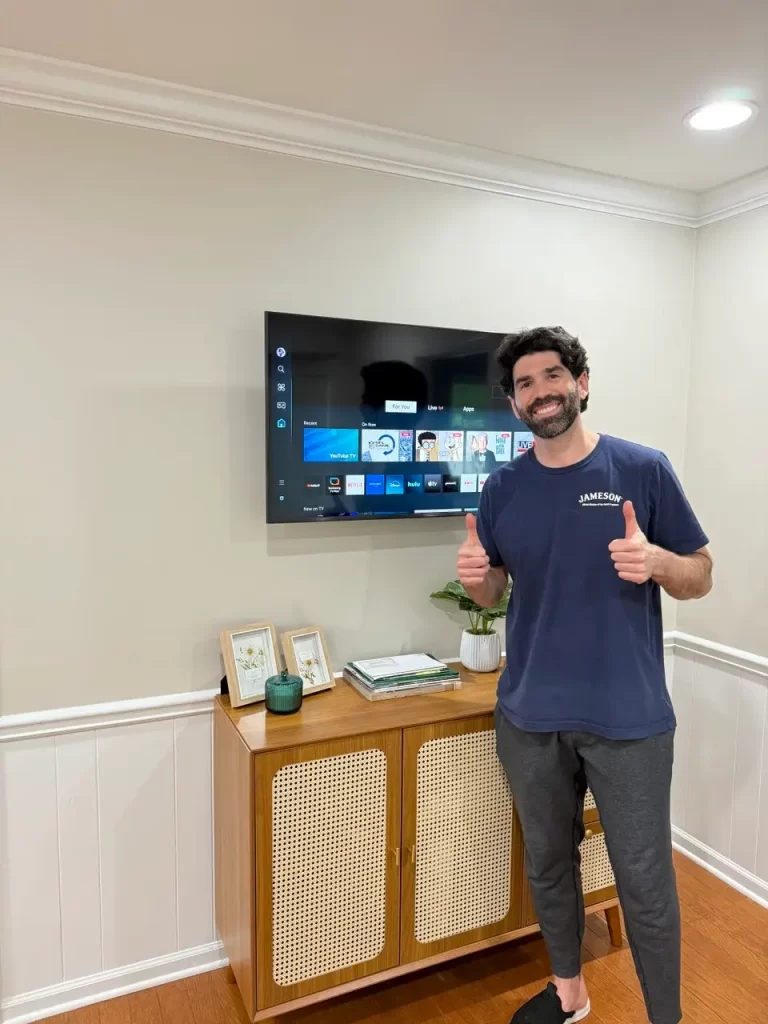 mart TV wall mounted above cabinet with happy client in Sandy Springs