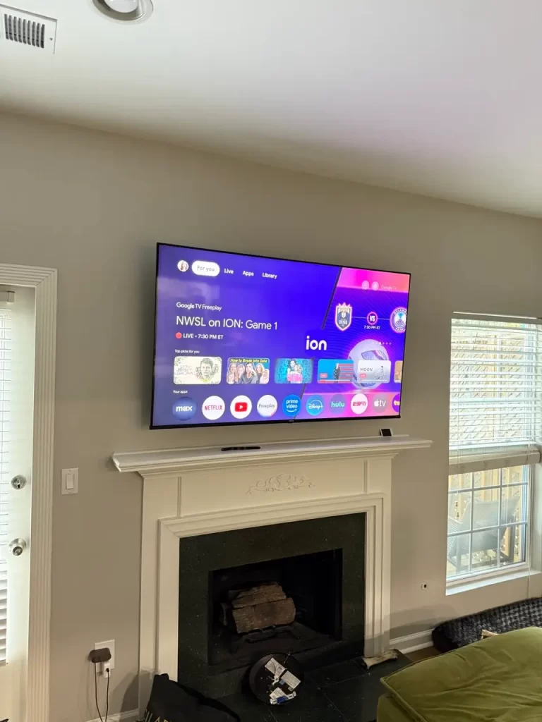 TV wall mounted above classic fireplace in Druid Hills home