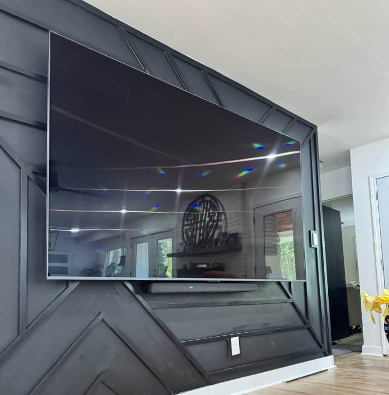 Flat screen TV mounted on black accent wall with hidden wiring – Atlanta